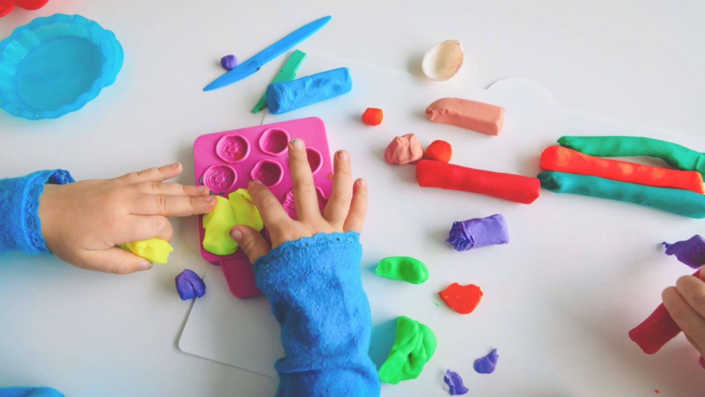 kids playing with colourful play-doh creating shapes and textures