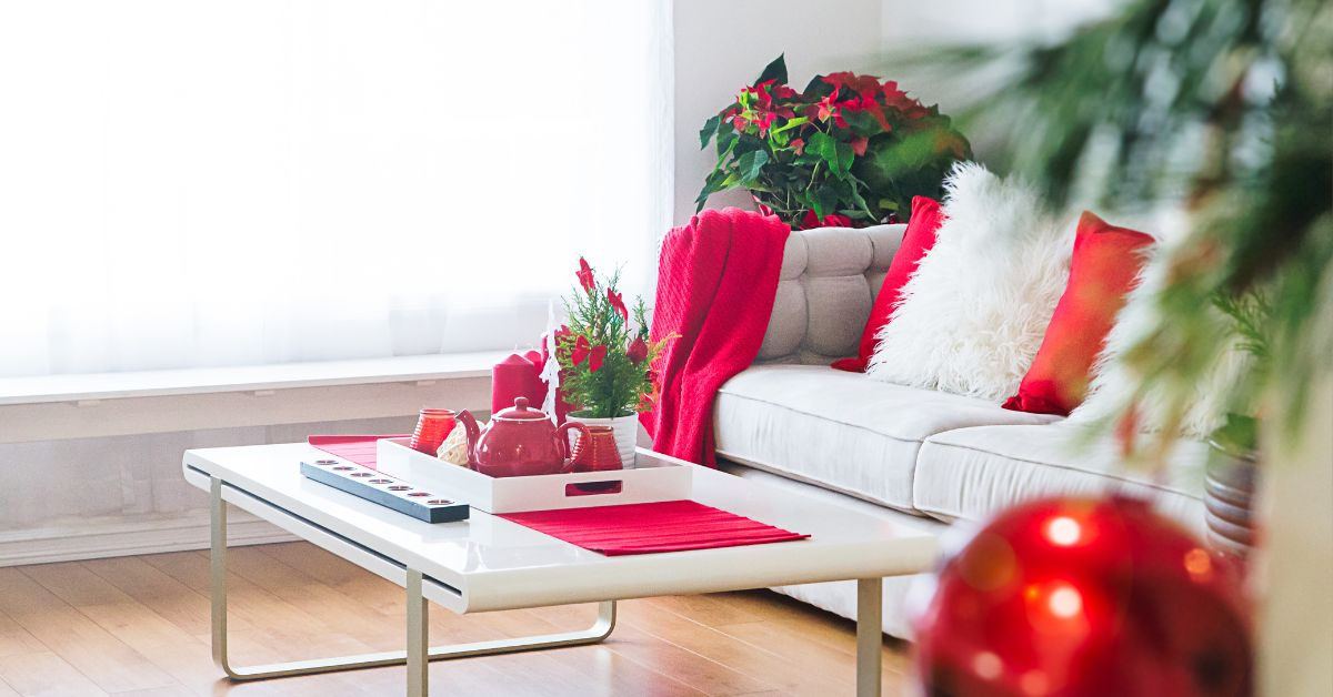 red and white christmas cushions and blanket on a white sofa