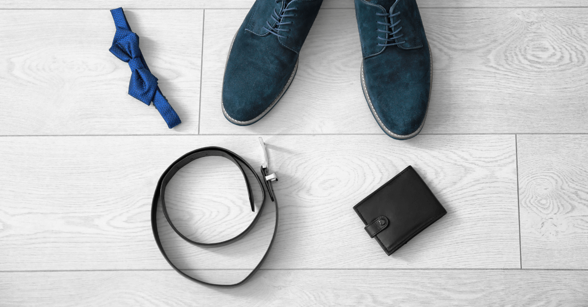 wooden floor featuring blue suede mens shoes, black belt, black wallet and blue bow tie