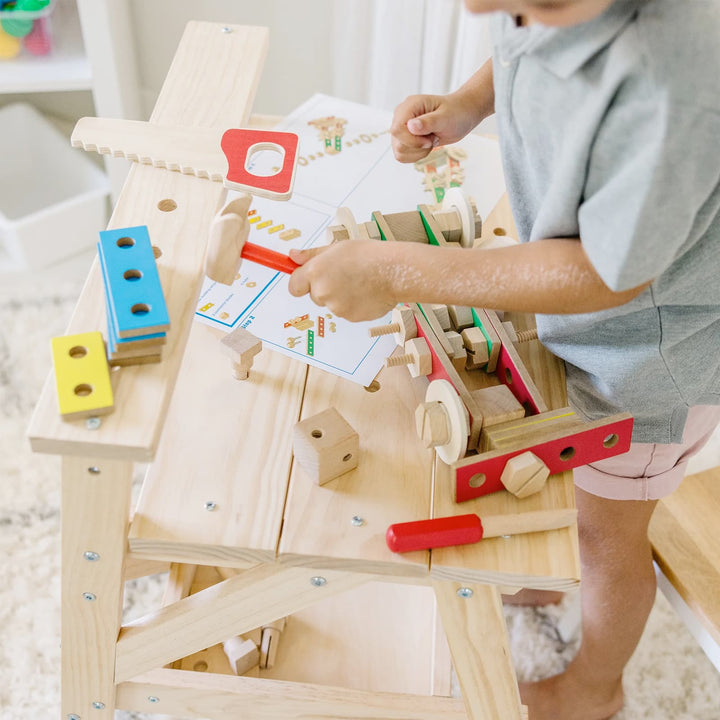 Child playing with a wooden workbench toy