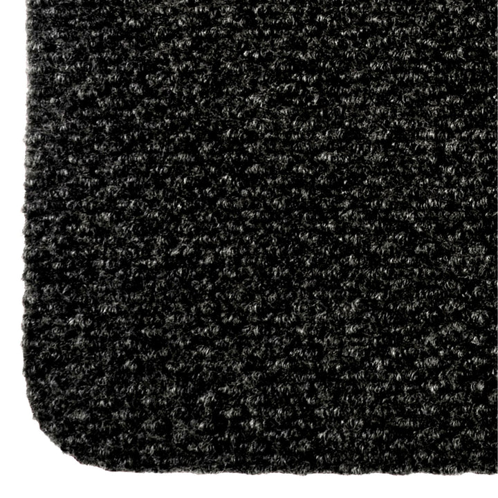 Close up of a black door mat with textured pile