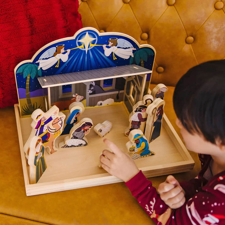 Child playing with a wooden nativity set for Christmas display