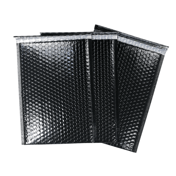 set of 3 black bubble mailers piled on top of each other on black background