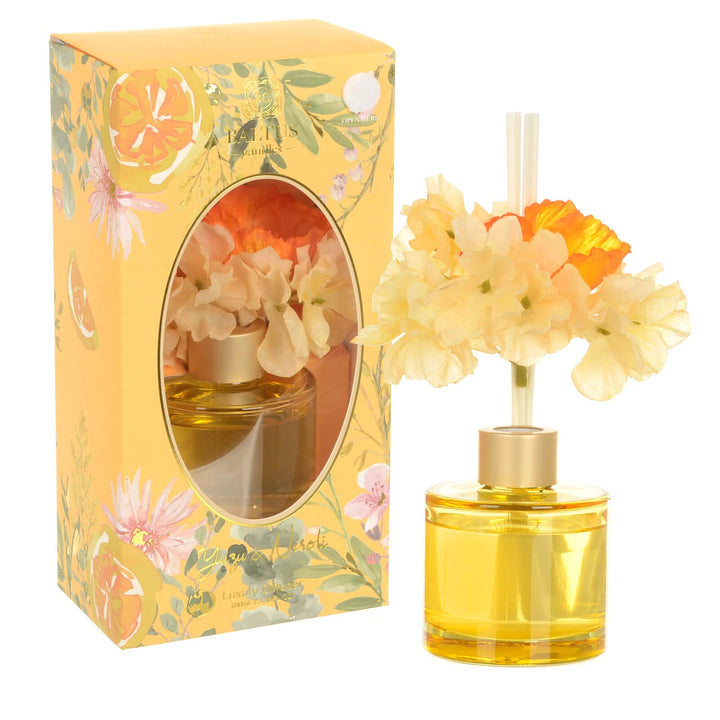 Yuzu and Neroli scented reed diffuser with yellow and ornage faux flowers and amber glass bottle