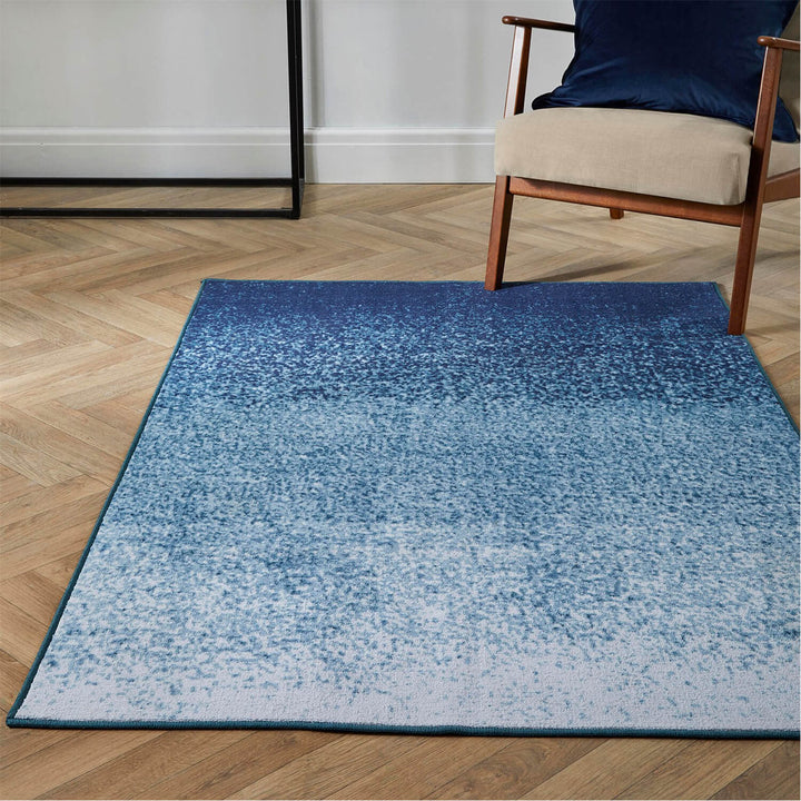 Blue ombre indoor rug on a wooden floor with armchair