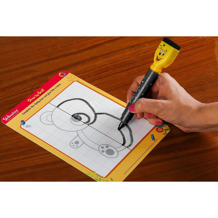 Hand writing with a Skilly Billy activity pen completing a reusable mat