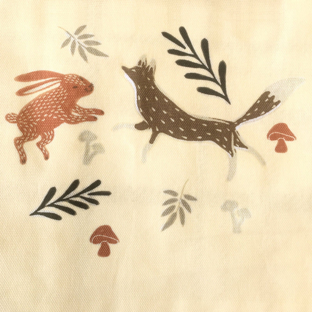 Close up of a hare fos leaves and toodstools on the front pocket of a kitchen apron