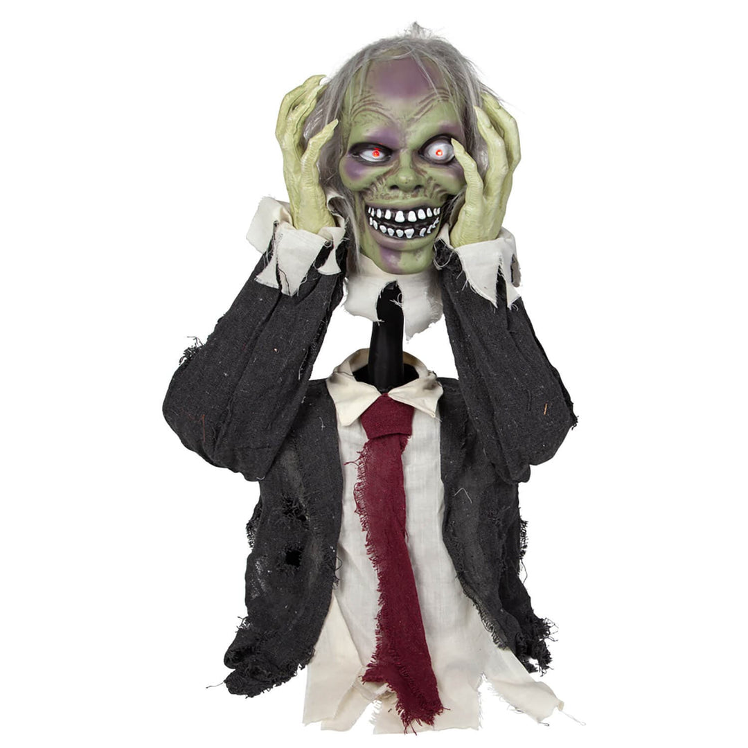 Green faced zombie figure with light up red eyes taking its head off its shoulders, dressed in a black jacket with red tie