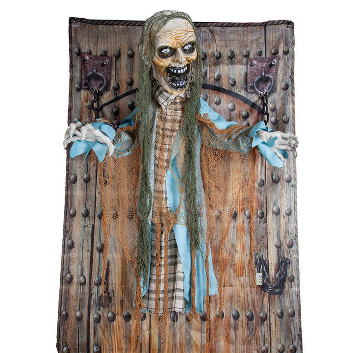 Zombie figure chained to a prison door with studs fr Halloween parties