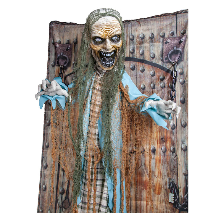 Close up of a moving Zombie figure shackled to a wooden door