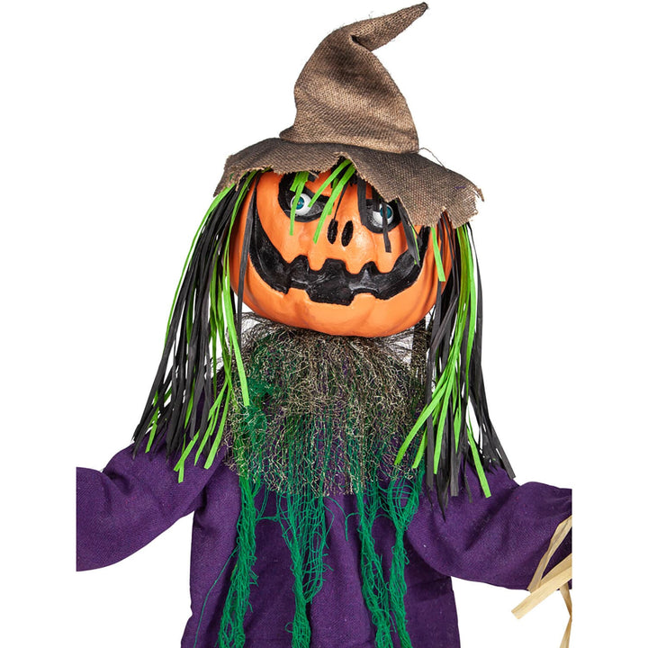 Close up of the orange pumpkin head on a dancing Halloween scarecrow figure