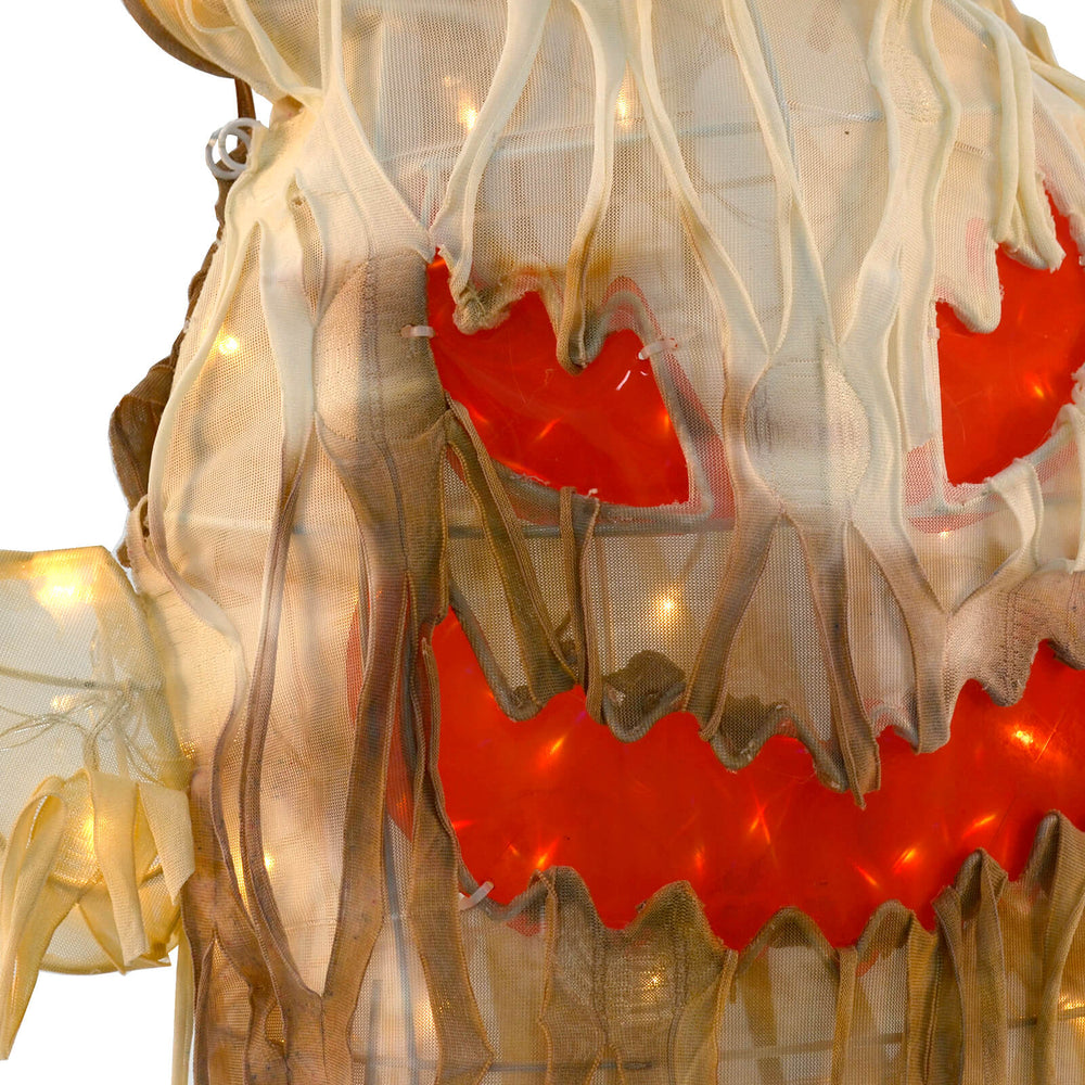 Close up of orange eyes and jagged mouth of a light up Halloween ghost prop