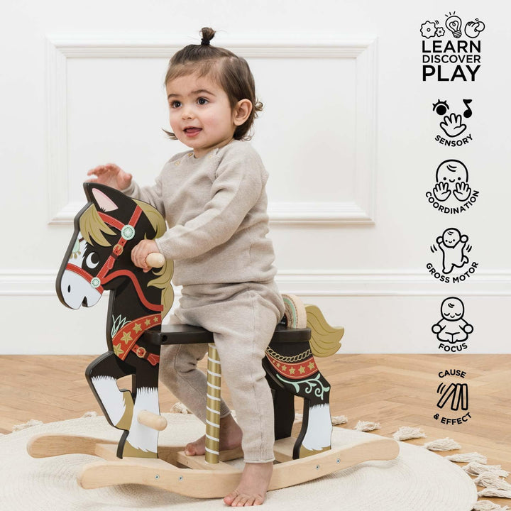 Child playing with a wooden rocking horse toy indoors.