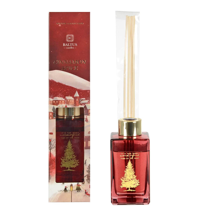 Red diffuser bottle with gold accents and Christmas tree design, next to its packaging.