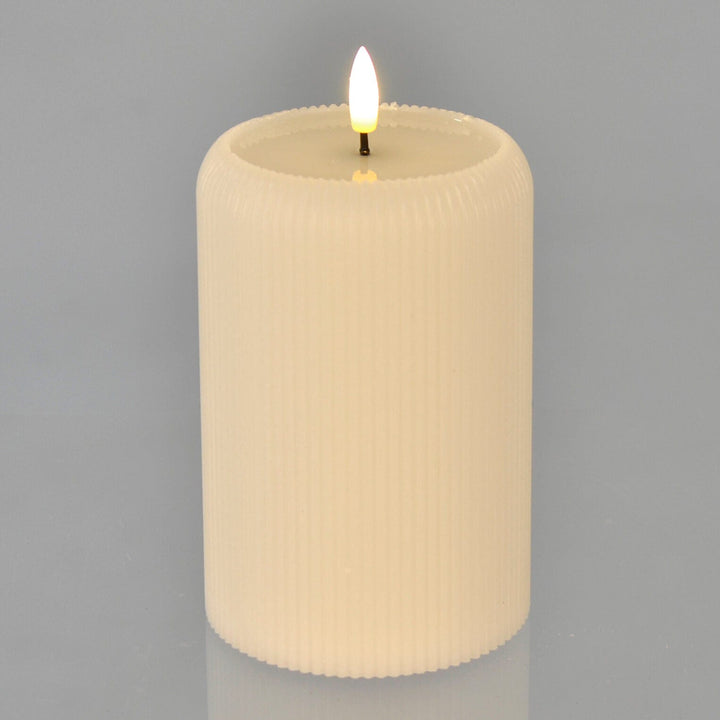 LED candle lit up on a grey background