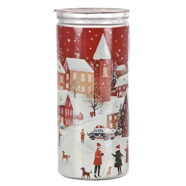 Christmas candle with a winter scene design featuring snow-covered houses and people.