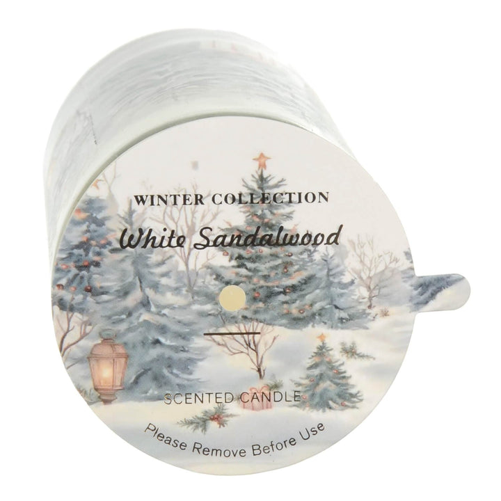 Scented candle with 'Winter Collection White Sandalwood' label and winter scene design.