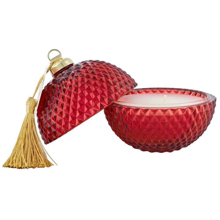 Side view of a red patterned glass bauble candle with lid and gold tassel
