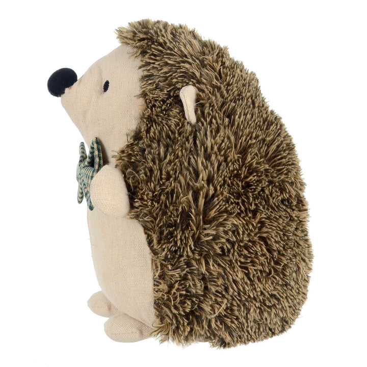 Side view of fabric hedgehog door stopper with a bow tie on a white background
