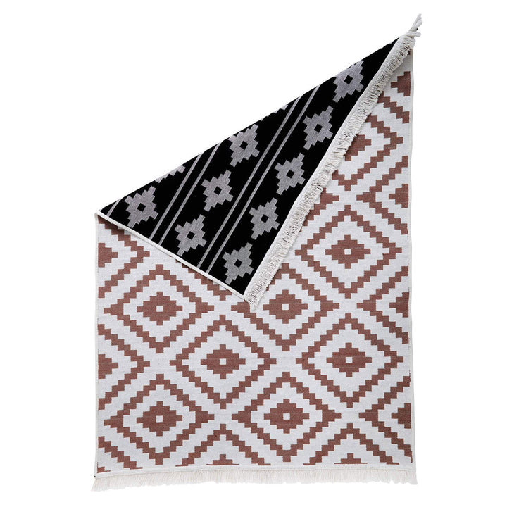 Brown geometric pattern rug with black aztec style reverse