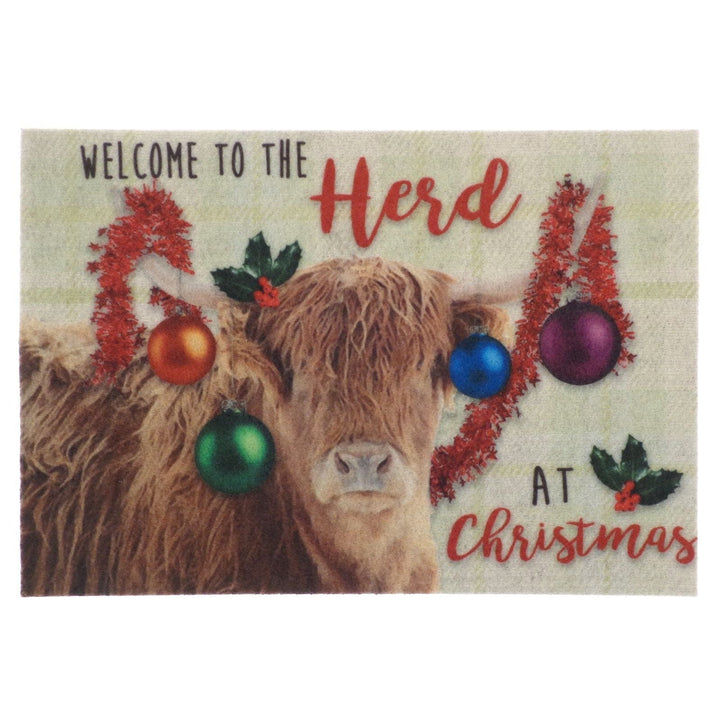 Doormat with a cow wearing Christmas bauble and tinsel decorations and text 'Welcome to the herd at Christmas'.