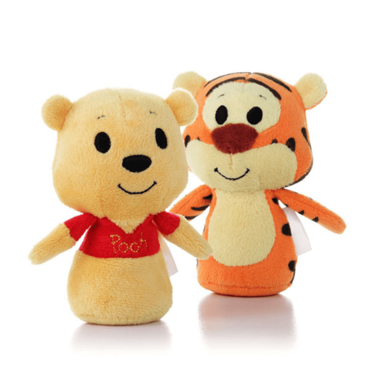 winnie the pooh and tigger plush toys side by side on white background