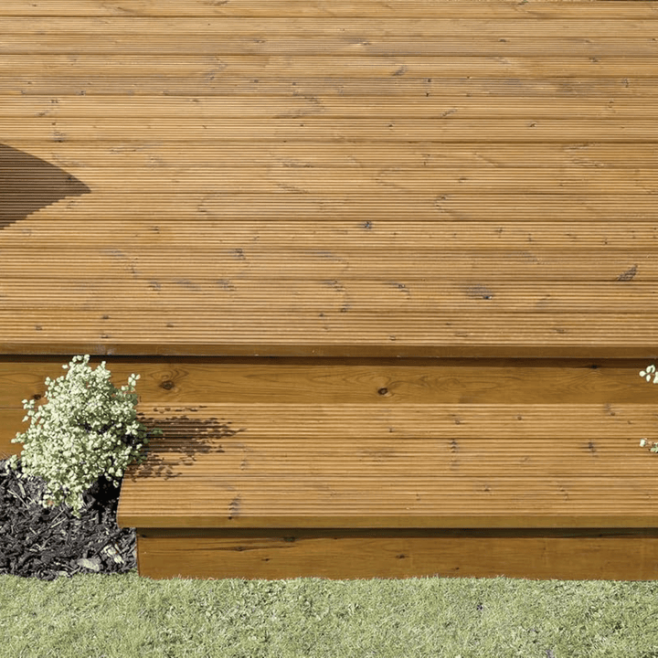 Wooden deck with grass and a small plant in the foreground