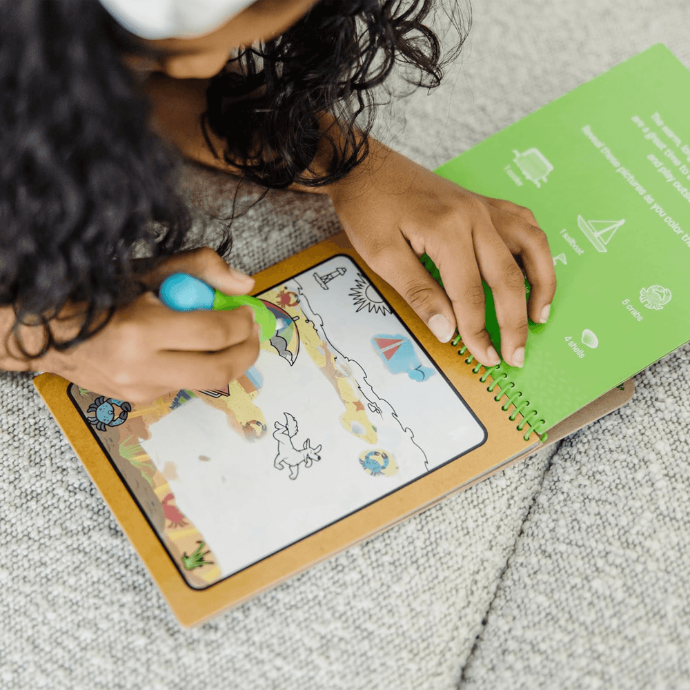 little girl uses water refil pen to reveal colourful sun umbrella