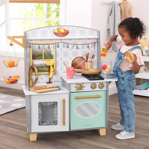 Girl playing with a pretend smoothie maker kitchen with blender over and freezer