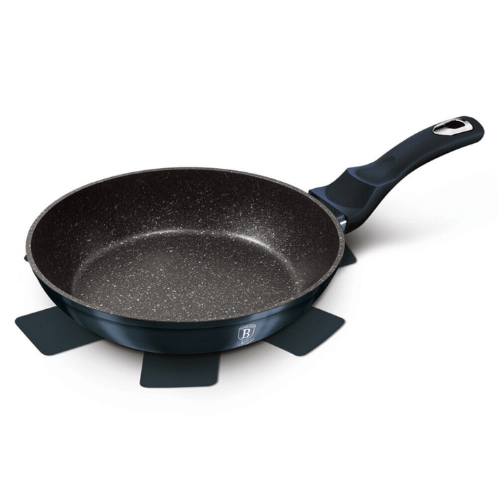 Black frying pan with speckled surface on a white background