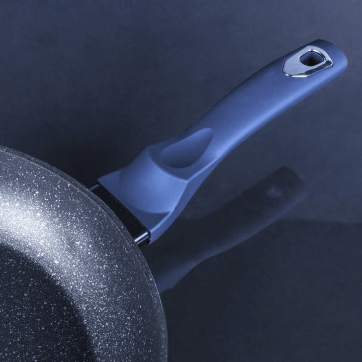 Close-up of a frying pan handle with a dark background