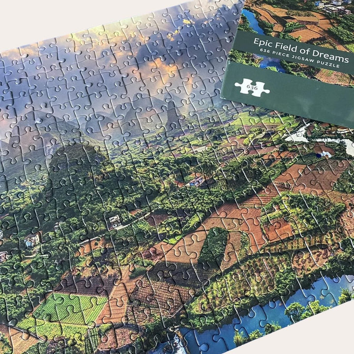 epic field of dreams jigsaw puzzle being completed on floor with box lid resting on top