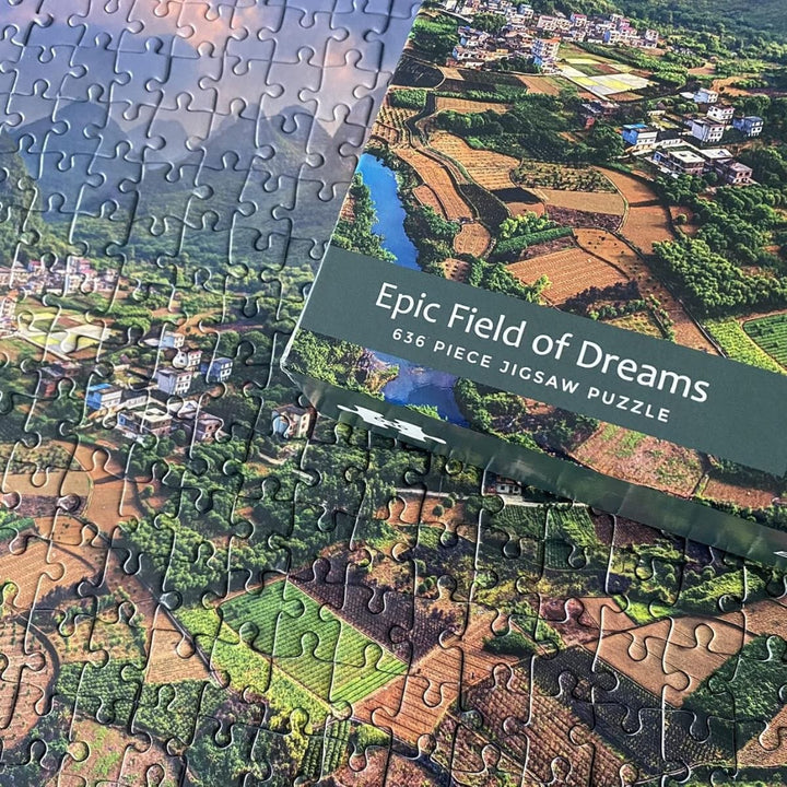 detail shot of box lid on top of jihsaw showing fields with crops, houses and nature scenery