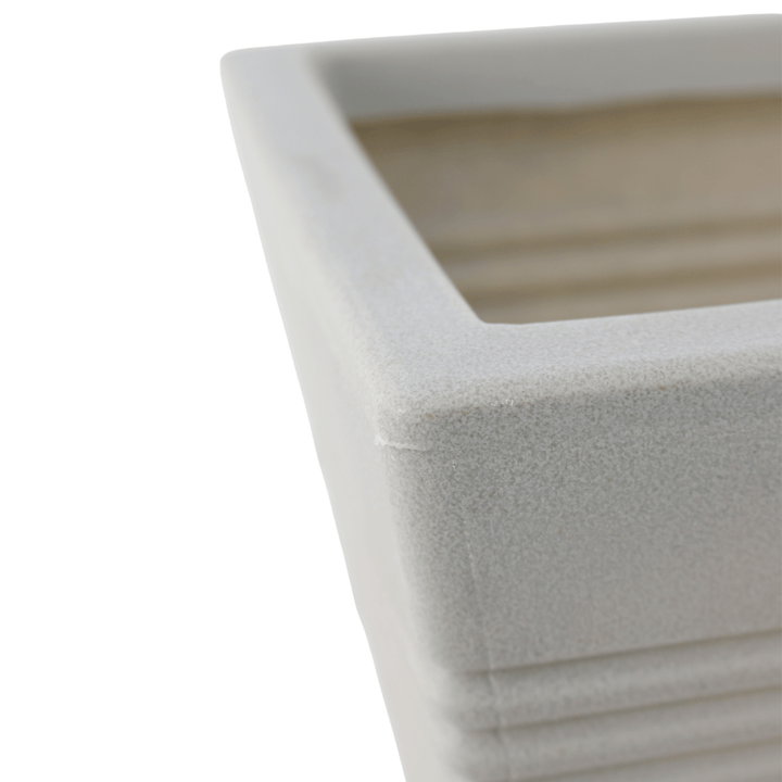 close up shot of stone colour plastic plant pot edge with speckled detail and ridged design