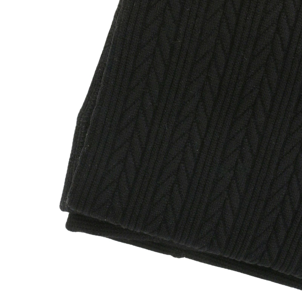 Close-up of a black cable knit style fabric on a white background