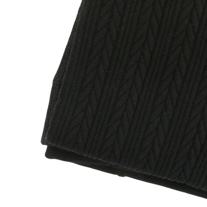 Close-up of a black cable knit style fabric on a white background