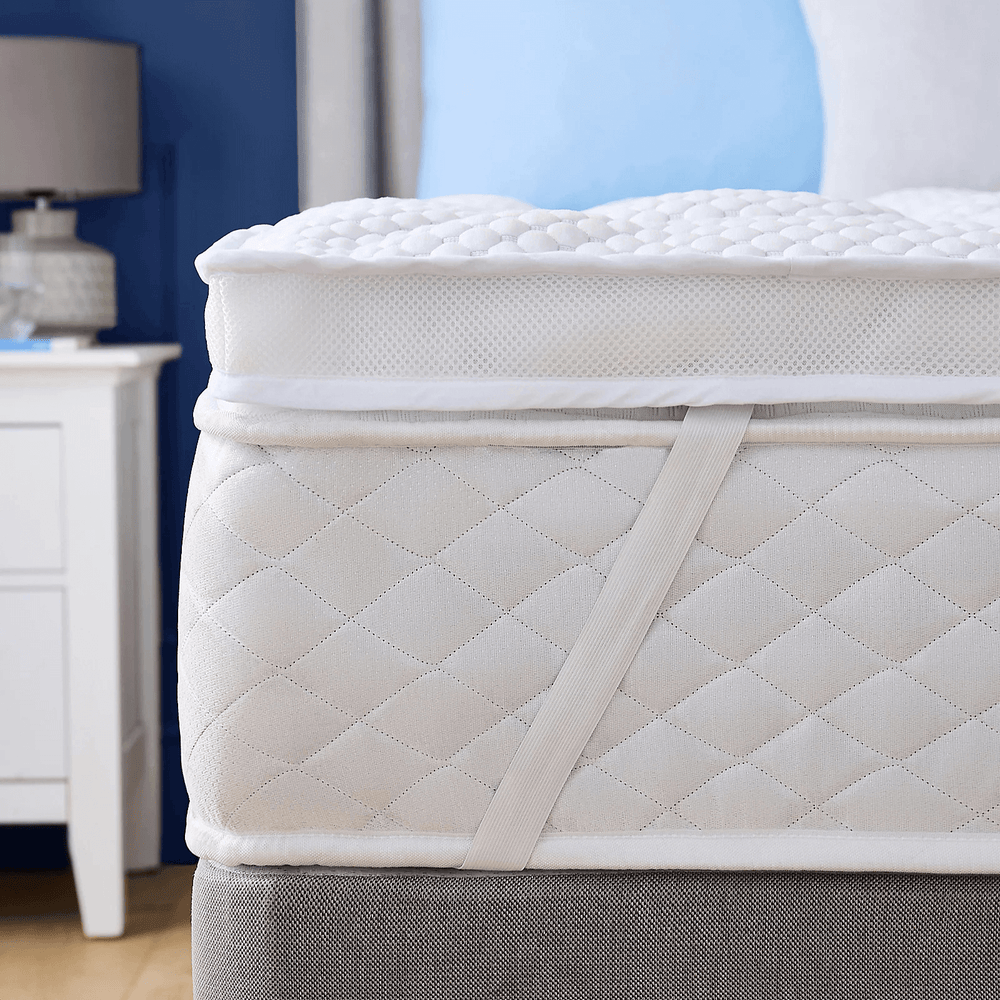 mesh mattress protector on a bed in a bedroom setting with easy fit straps