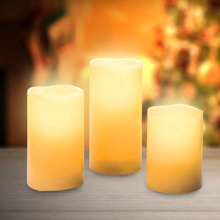 3 lit warm white LED candles on a wooden table