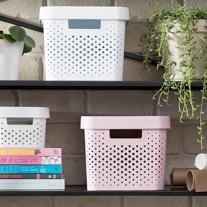 Curver storage baskets in pink and white on shelves with books and plants