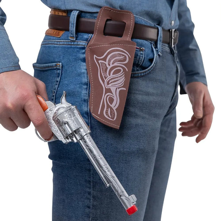 Person holding a cowboy revolver with brown holster for fancy dress costumes