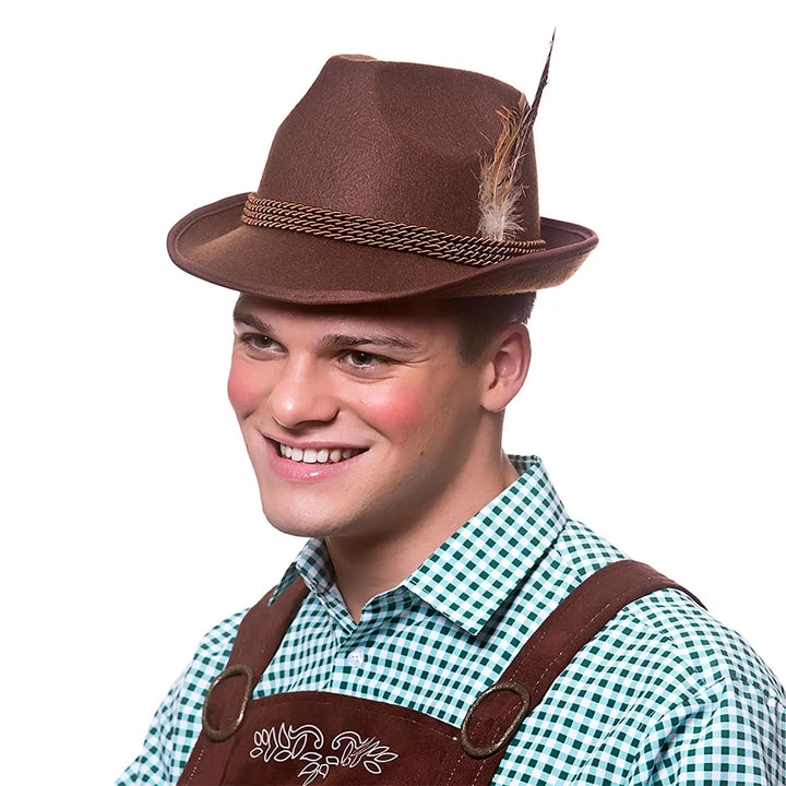 Man wearing lederhosen and a brown felt bavarian hat with braid and feathers for beer festival fancy dress
