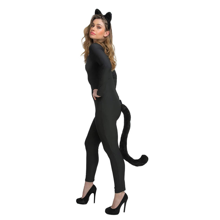 Woman wearing a black cat-themed outfit with ears and tail on a white background