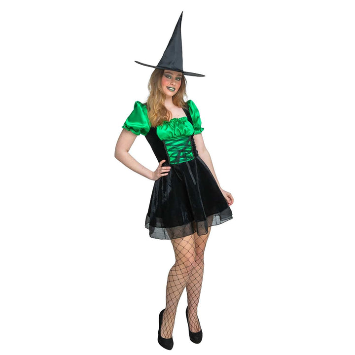 Woman wearing a green and black sexy witch costume with a pointed hat on a white background