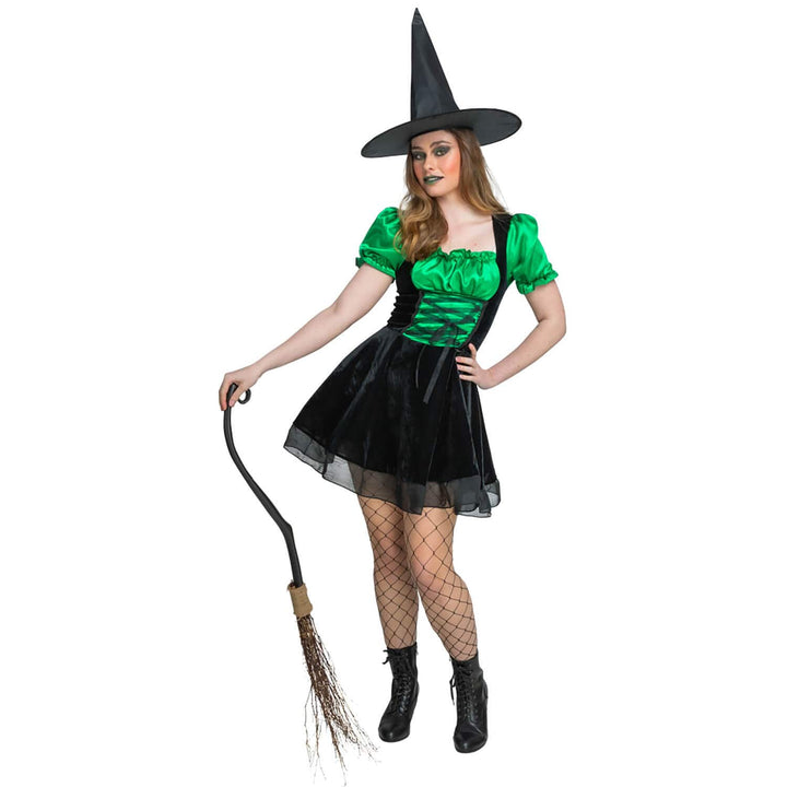 Woman in a greenand black witch costume holding a broom on a white background
