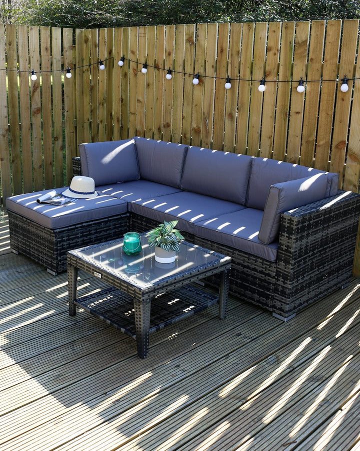 monaco 5 piece sofa set viewed from side on patio space with festoon lights, sun hat and plants and candle on table top