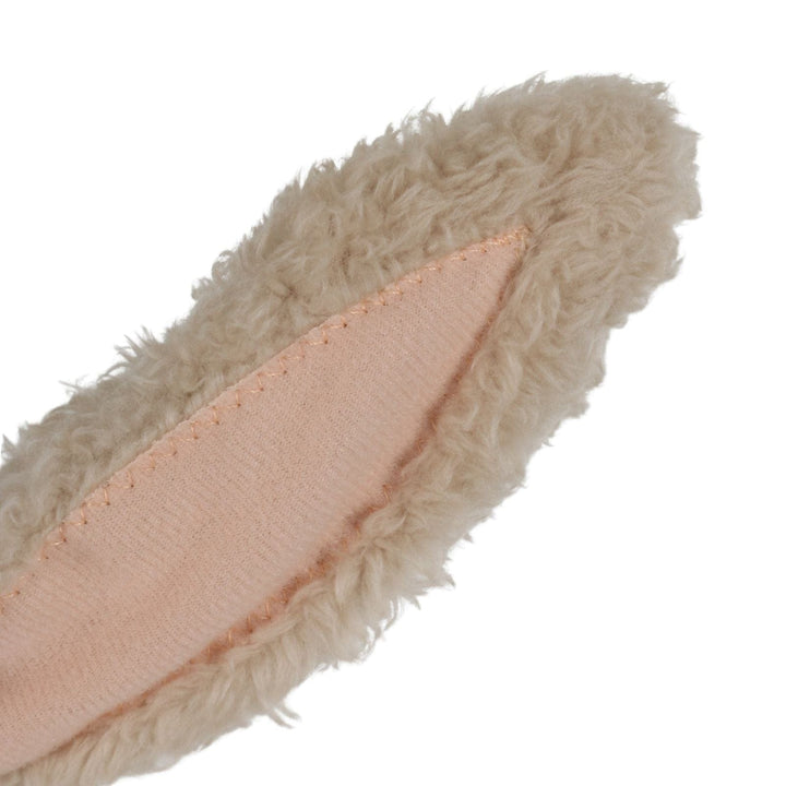 Close-up of a beige fuzzy rabbit ear with a pink interior on a white background