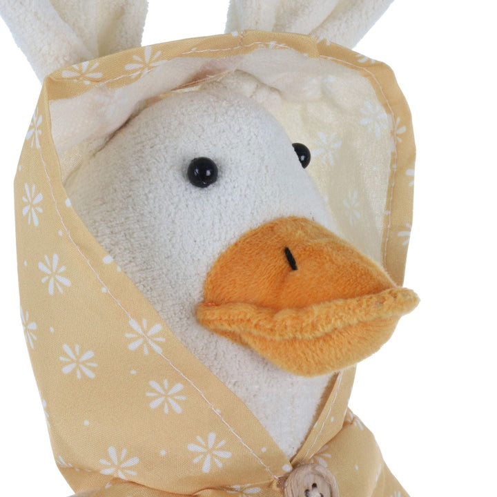 Plush duck figure wearing a yellow raincoat with white floral patterns on a white background
