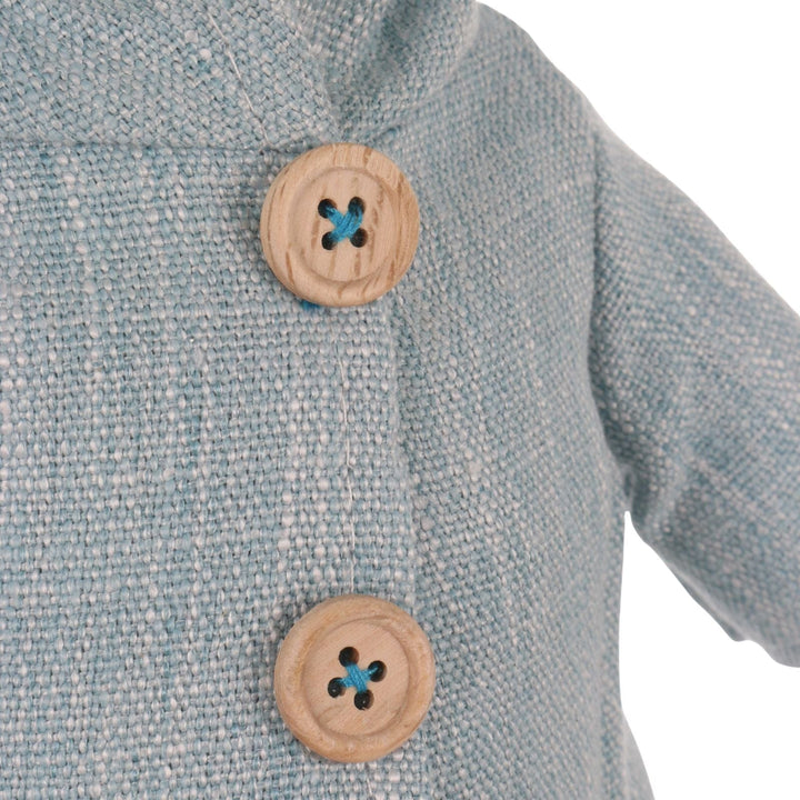 Close-up of a textured fabric with wooden buttons featuring blue sewn centres