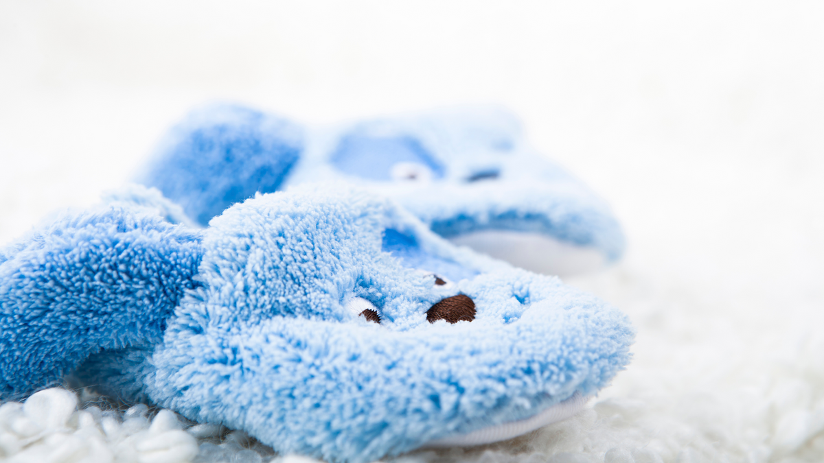 boys blue rabbit slippers on a white rug