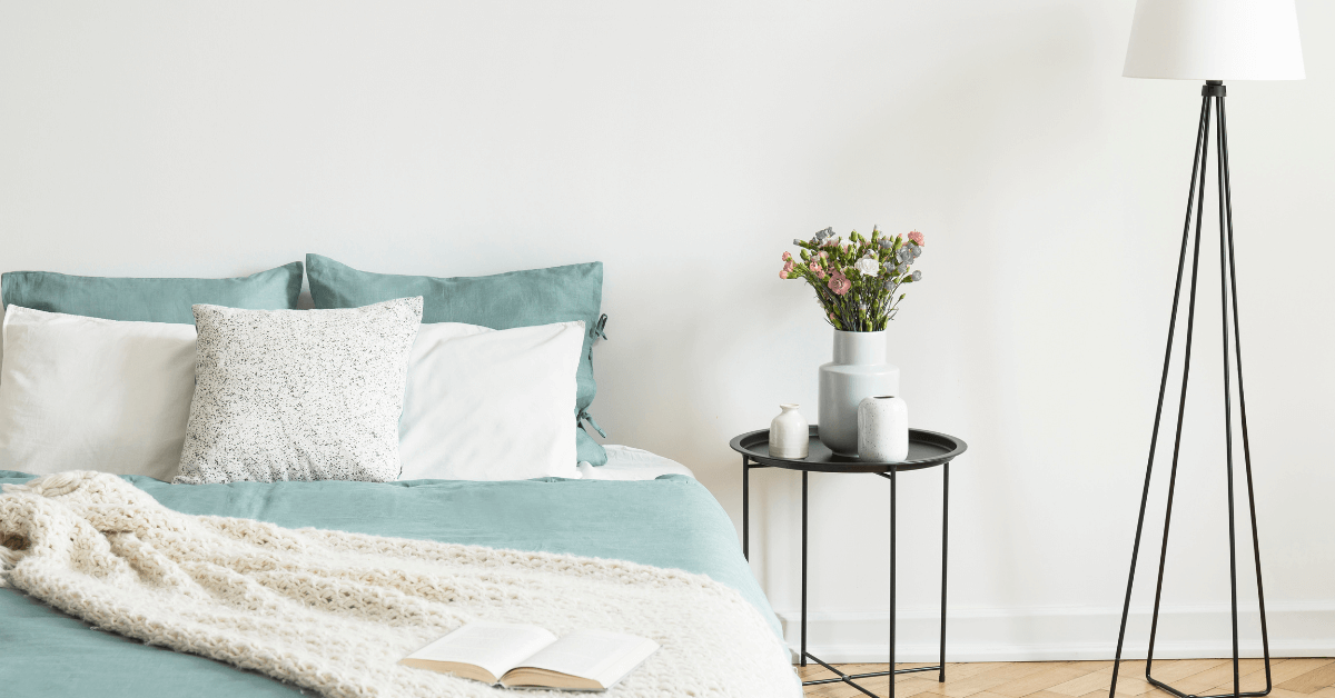grey storage ottoman opened with grey blanket hanging over edge